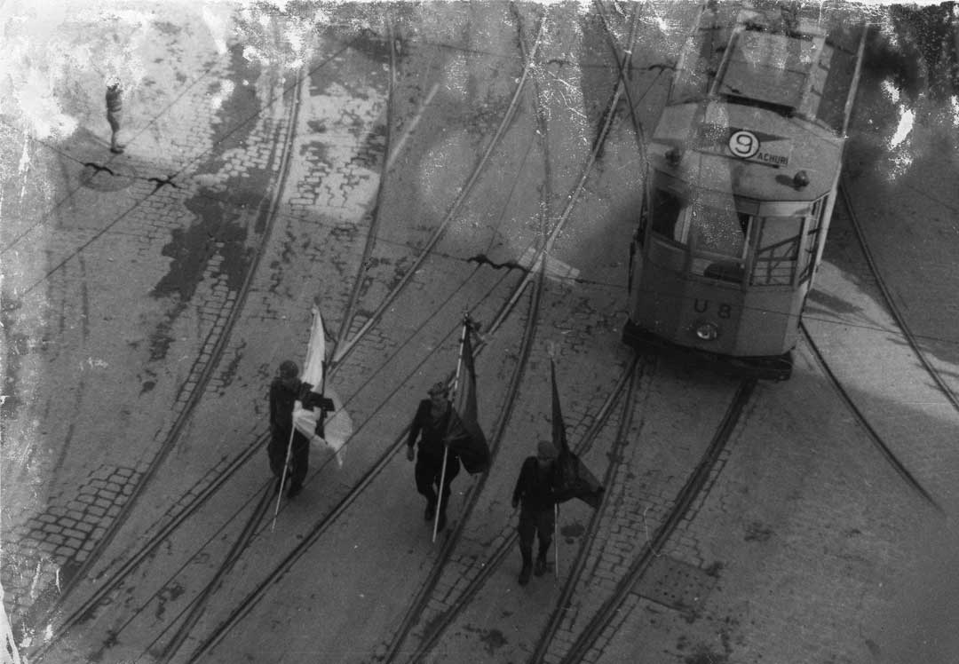 Entrada de las tropas franquistas en Bilbao.Tres soldados desfilan junto al tranvia de Atxuri portando las banderas, española, carlista y falangista.