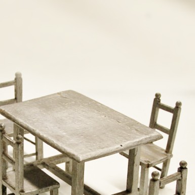 Imagen de una mesa junto a unas sillas de madera