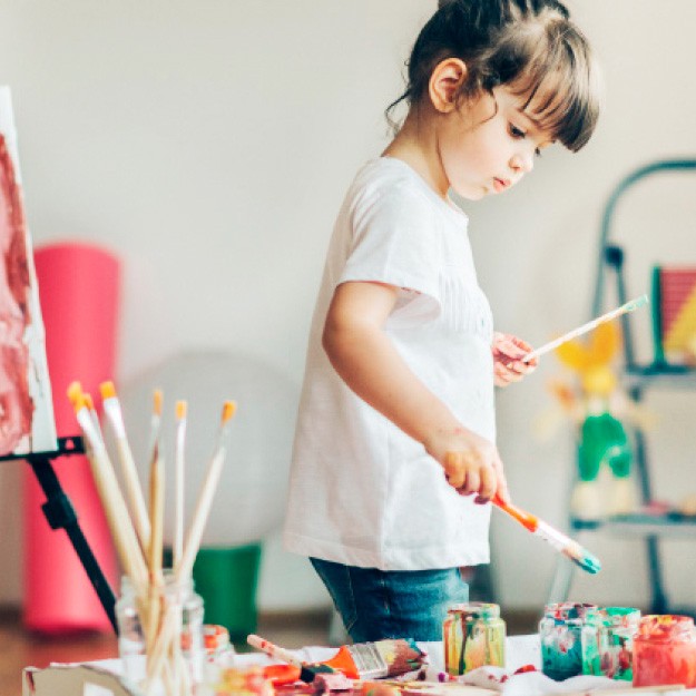 Imagen de una niña de unos 2 años con pinceles